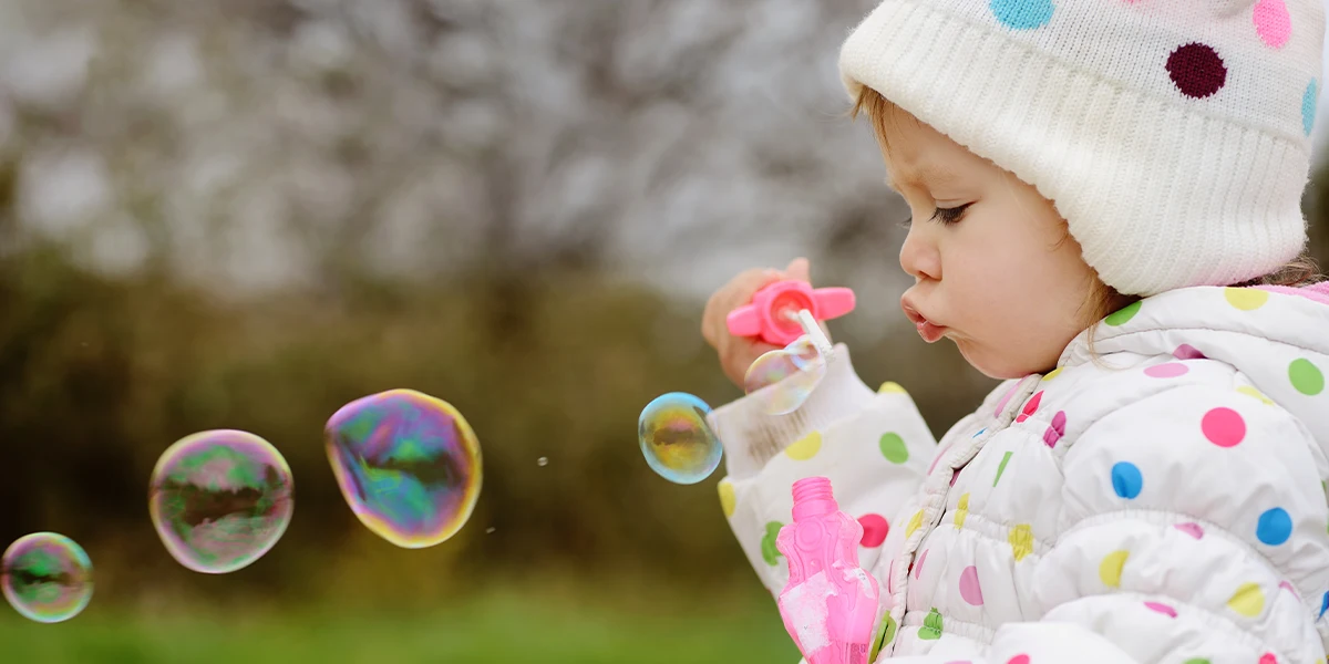 عکاسی از کودک در حال بازی با حباب‌ها در عکستو 